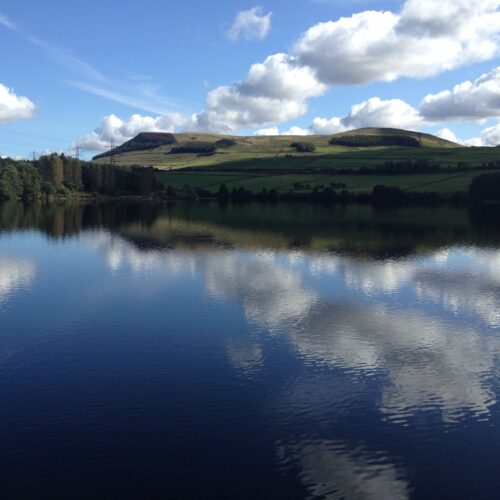 Landscape view of a reservoir surrounded by green hills