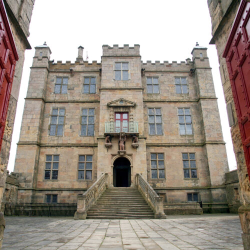 Bolsover Castle frontage viewed through the main red gates