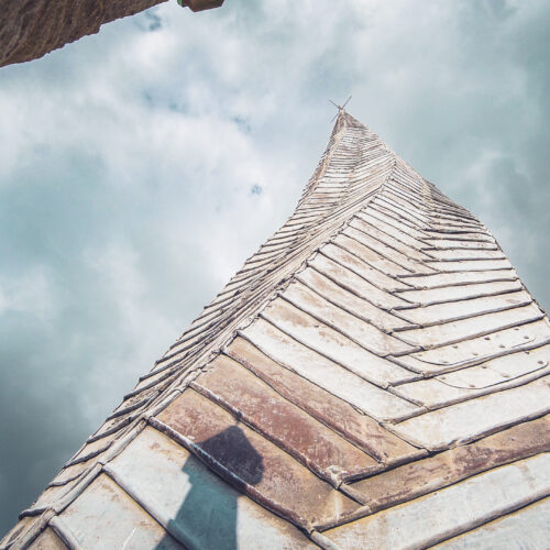 View of the crooked wooden church spire looking upwards to the sky