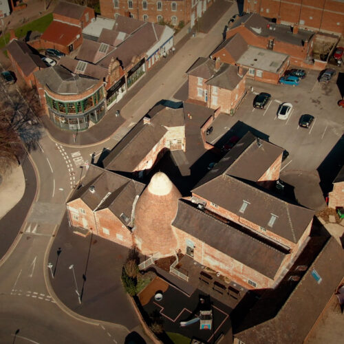 Aerial photo of Sharpe's Pottery Museum showing a white-topped pottery bank surrounded by red brick industrial buildings