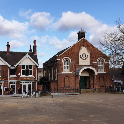 View of town square looking across to a red brick former Methodist Chapel and a pub